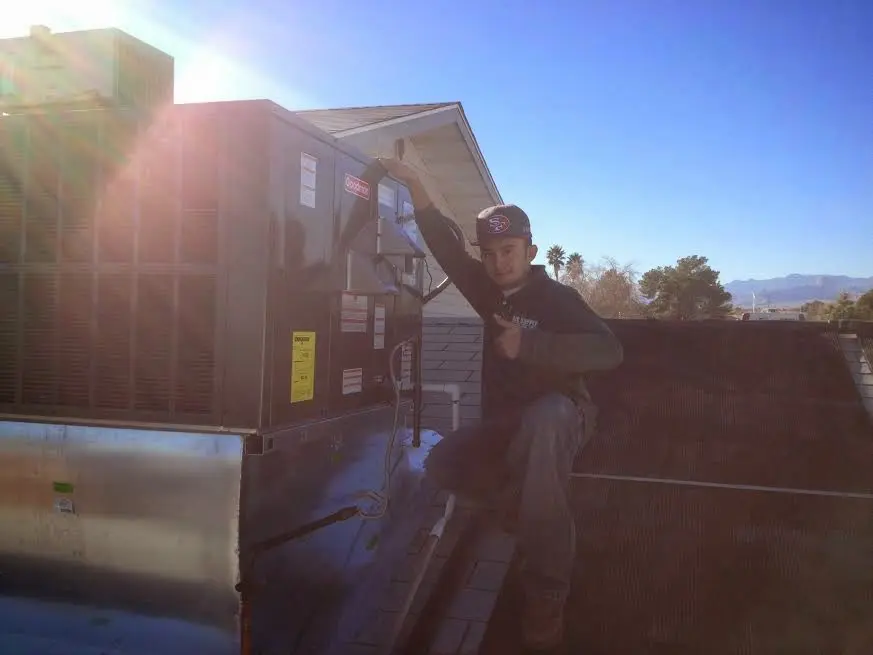 HVAC technician performing AC Tune-Up on a rooftop unit in Brevard